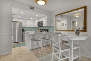 a kitchen with a table and chairs and a refrigerator at Comfort by the Beach - Heated Pool & Private Beach in Cape Canaveral