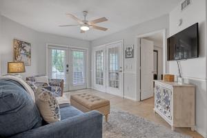 a living room with a blue couch and a ceiling fan at Comfort by the Beach - Heated Pool & Private Beach in Cape Canaveral