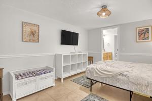 a bedroom with a bed and a flat screen tv at Comfort by the Beach - Heated Pool & Private Beach in Cape Canaveral +36 photos