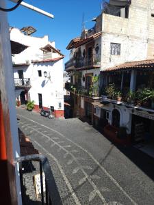 an empty street in a town with buildings at Camino Santa Prisca in Taxco de Alarcón +7 photos