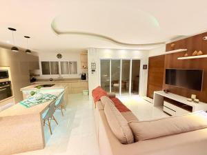 un soggiorno e una cucina con un divano e un tavolo di Sauna Piscina e Vista Nova e Confortável a Passa Quatro