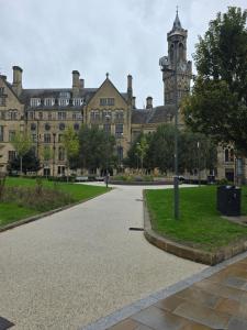 a large building with a clock tower in front of it at Oge's Apartment in Bradford