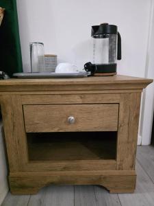 a wooden dresser with a coffee maker on top of it at Oge's Apartment in Bradford