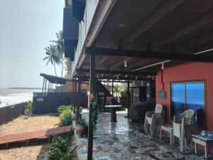 a restaurant on the beach with chairs and tables at Adinam's Beach Retreat in Nyanyanu