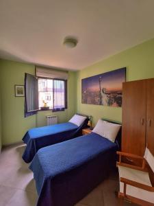 a bedroom with two beds and a window at Lago Maggiore Gardens Apartment in Intra