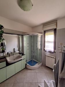 a large bathroom with a shower and a sink at Lago Maggiore Gardens Apartment in Intra