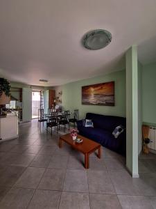 a living room with a blue couch and a table at Lago Maggiore Gardens Apartment in Intra
