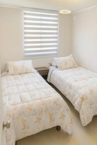 Dos camas una al lado de la otra en un dormitorio. en Moderno Depto 3D 2B con Estacionamiento en Concepcion, en Concepción 4 fotos más