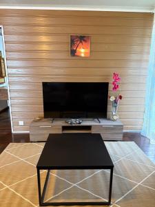 a living room with a coffee table and a flat screen tv at Fare Vaitaua in Faaone