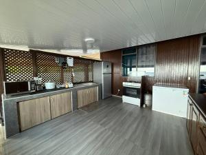 a large kitchen with wooden floors and wooden cabinets at Fare Vaitaua in Faaone