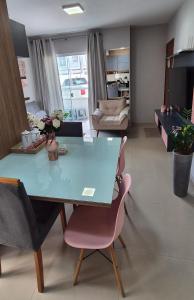 a living room with a blue table and chairs at Acomodação Quartzo Rosa - Apartamento Completo in Palhoça