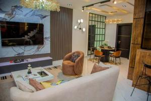 sala de estar con sofá y TV grande en Aviv Luxury Homes, en Enugu