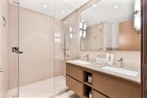 a bathroom with two sinks and a glass shower at 2Bed with spectacular Burj Khalifa & fountain view in Dubai +15 photos