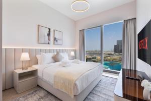 a white bedroom with a bed and a large window at 2Bed with spectacular Burj Khalifa & fountain view in Dubai