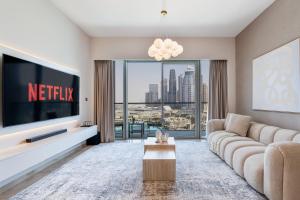 a living room with a television and a couch at 2Bed with spectacular Burj Khalifa & fountain view in Dubai