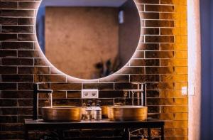 a bathroom with two sinks and a mirror on a brick wall at Privespa Calma in Tilburg +8 photos