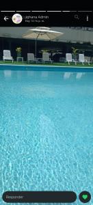 a large pool of blue water with chairs and tables at Habitación en Ph Mistyc Towers in Panama City