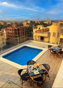 a balcony with a table and chairs and a swimming pool at SOFIA PYRAMIDS & SPHINX HOTEL with free pool access in Cairo