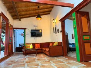 a living room with a couch and a tv at Casa & cabaña campestre equipadas, 13 personas, familias in Jardin