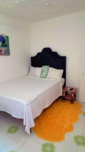 a bedroom with a large white bed with a headboard at Tamaras Inn in Ocho Rios