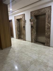 a hallway with two doors and a tile floor at Jawharet karam in El Aouina Station