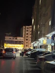 two people walking down a city street at night at Jawharet karam in El Aouina Station