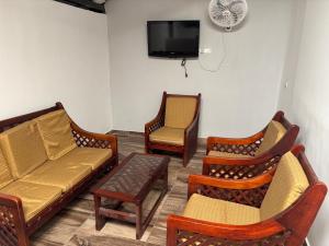 a living room with three chairs and a couch and a tv at Casa Hotel San Gil in San Gil
