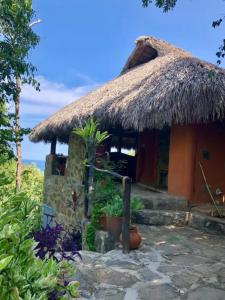 a small house with a thatched roof at Villa Nanami in Arroyo Cruz