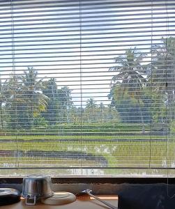 a window with a view of a palm tree at The Mandalika Rinjani Lombok in Masbagik