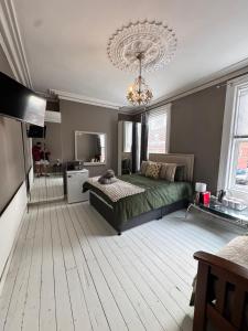 Un dormitorio con una cama y una lámpara de araña. en Cozy House Great Location, en Belfast