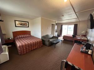 una stanza d'albergo con un letto e una sedia di Northern Lights Inn & Suites a Valleyview