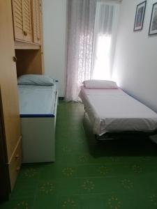 Dos camas en una habitación con suelo verde. en Gabry's, en Roma