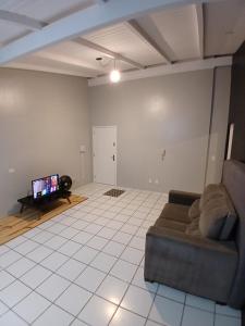 a living room with a couch and a flat screen tv at Cobertura próximo a Oktoberfest! in Blumenau +5 photos