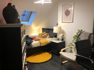a small bedroom with a bed and a chair at City Escape Space in Chaumont