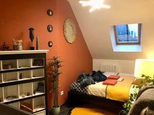 a bedroom with a bed and an orange wall at City Escape Space in Chaumont