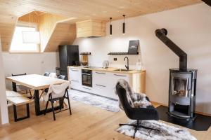 a kitchen and dining room with a wood stove at TDI - Modern 2-Bedroom Apartment in nature in Kanji Dol