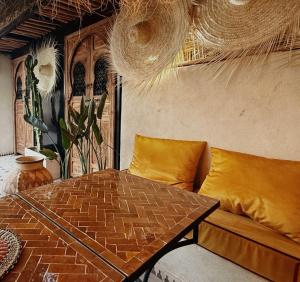 una sala de estar con una mesa y un sofá en Riad Dar Lghizlane, en Marrakech 110 fotos más