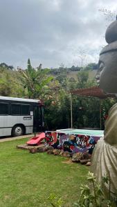 a bus is parked in front of a park with avertisement at Ônibus Oriental com Ofurô - Domingos Martins ES in Domingos Martins