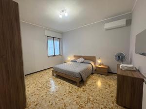 a bedroom with a bed and a desk and a fan at Casa Ortensia Saronno in Saronno