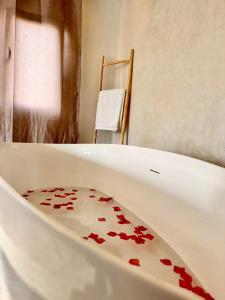 a white bath tub filled with red petals at Soho Secret Studio - Romantic Getaway in Essaouira in Essaouira