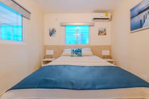 a bedroom with a large bed and two windows at Oasis cerca del mar #1 in El Higo