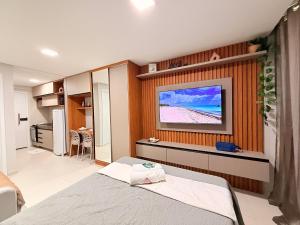 a bedroom with a television on a wall at Açores Tamandaré Flats By HM in Tamandaré