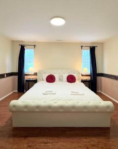 a bedroom with a large white bed with red pillows at Charming 1 br Retreat in South Surrey White Rock in Surrey