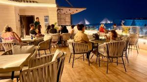 a group of people sitting at tables in a restaurant at New Museum Guest House, Pyramids View in Cairo
