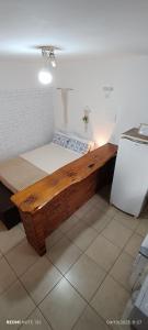 a bedroom with a wooden bed in a room at Studio Baleia Franca in Imbituba