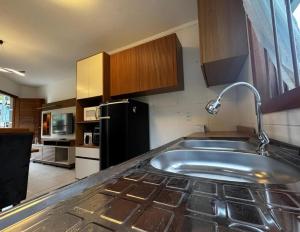 a kitchen with a sink and a refrigerator at Casa no bairro Germânia in Santa Cruz do Sul