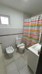 a bathroom with a toilet and a sink and a shower curtain at Casa Amplia in Río Grande +3 photos