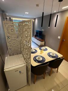 ein Esszimmer mit einem Tisch und Stühlen sowie einem Kühlschrank in der Unterkunft Condominio Brisas do Lago in Brasilia