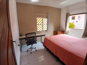 a bedroom with a desk and a bed and a chair at Casa COP30 in Ananindeua +2 photos