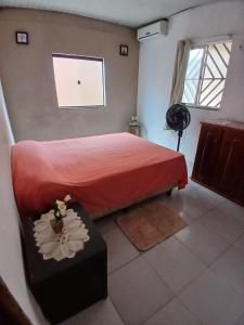 a bedroom with a red bed and a window at Casa COP30 in Ananindeua